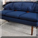 F38. Bench with navy blue upholstery and wooden legs. 18”h x 56”w x 22”d 